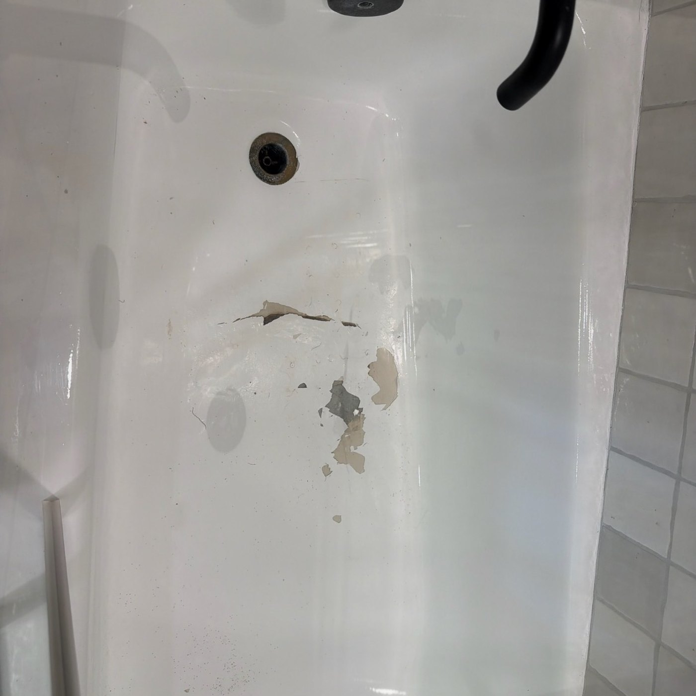 Before — a tub floor cracked near the drain where an earlier repair failed and lifted.